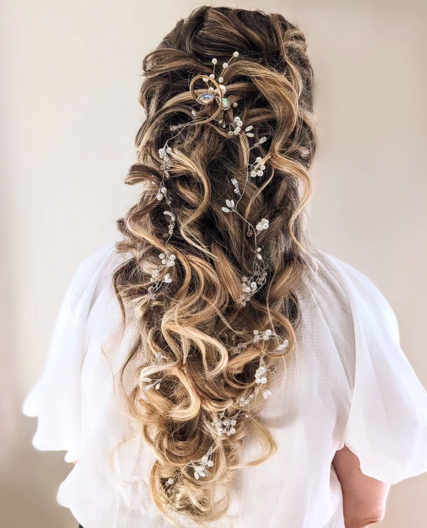 a boho bridal hair look with long brown hair with blonde highlights and baby's breath accessories